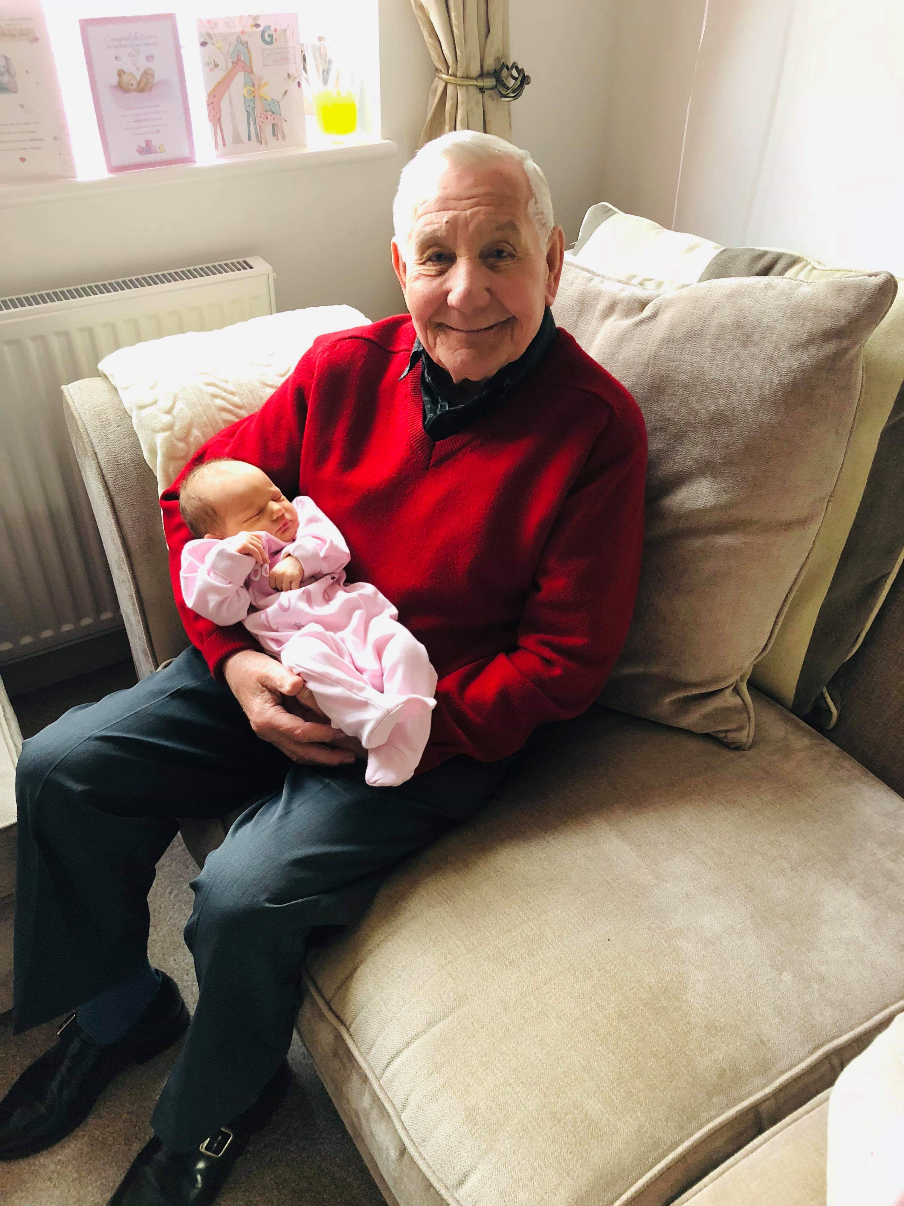 An image of George Fawcett holding one of his great-grandchildren