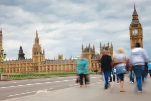 Image of people walking across Westminster Bridge towards Houses of Parliament