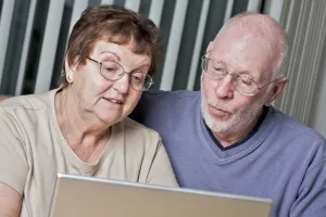 Elderly couple looking at laptop