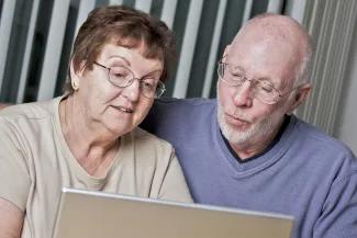 Elderly couple looking at laptop