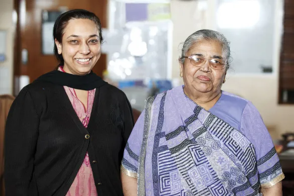 An indian woman and her mother looking at the camera